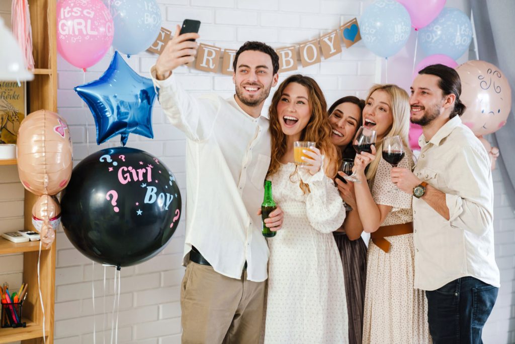 Öt fiatal felnőtt csoportja megoszt egy selfie-t bolondos babaérkezési buli közben.