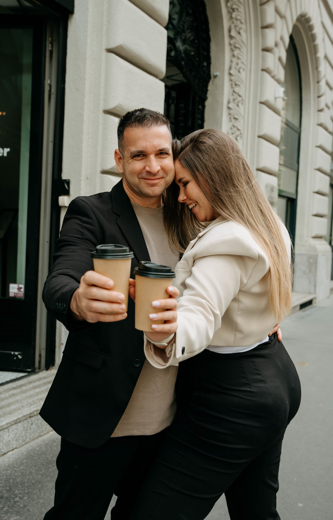 Online esküvői meghívó minta - feree & dóri 2 Feree és Dóri kávéspohárral koccint egy budapesti utcán - online esküvői meghívó minta